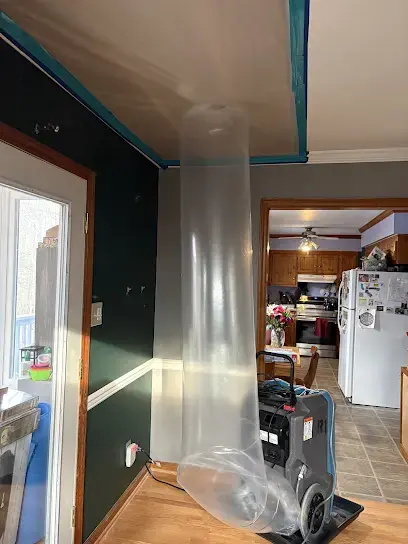 Plastic containment column and a dehumidifier set up during a water damage dry-out in a Garner area home