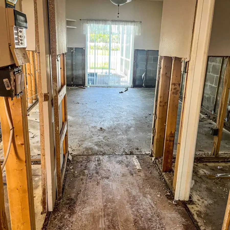 Room with flood-cut walls and a wet, stripped floor documented before drying in a Garner area home