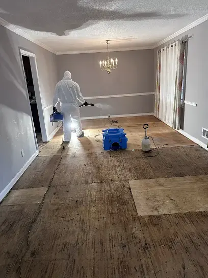 Drying equipment running in a room of a Clayton home with a moisture meter and notes on a clipboard beside it