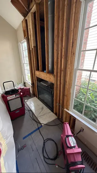 Air movers and a dehumidifier drying the floor of a living room in a Cary home after a water loss